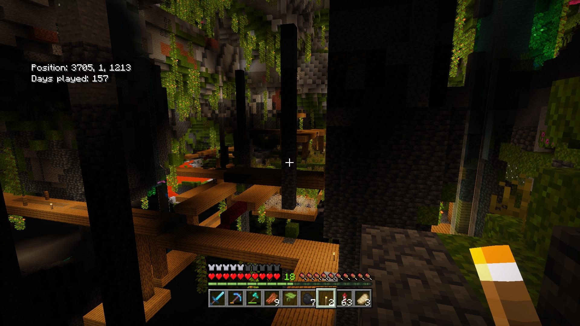 An exposed mineshaft in a huge lush cave with glowberries hanging from the cave ceiling
